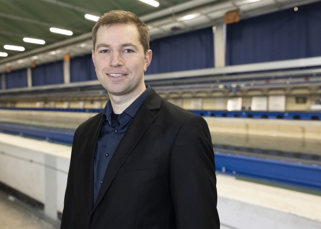 David Frank steht vor dem Schleppkanal in der Strömungshalle.