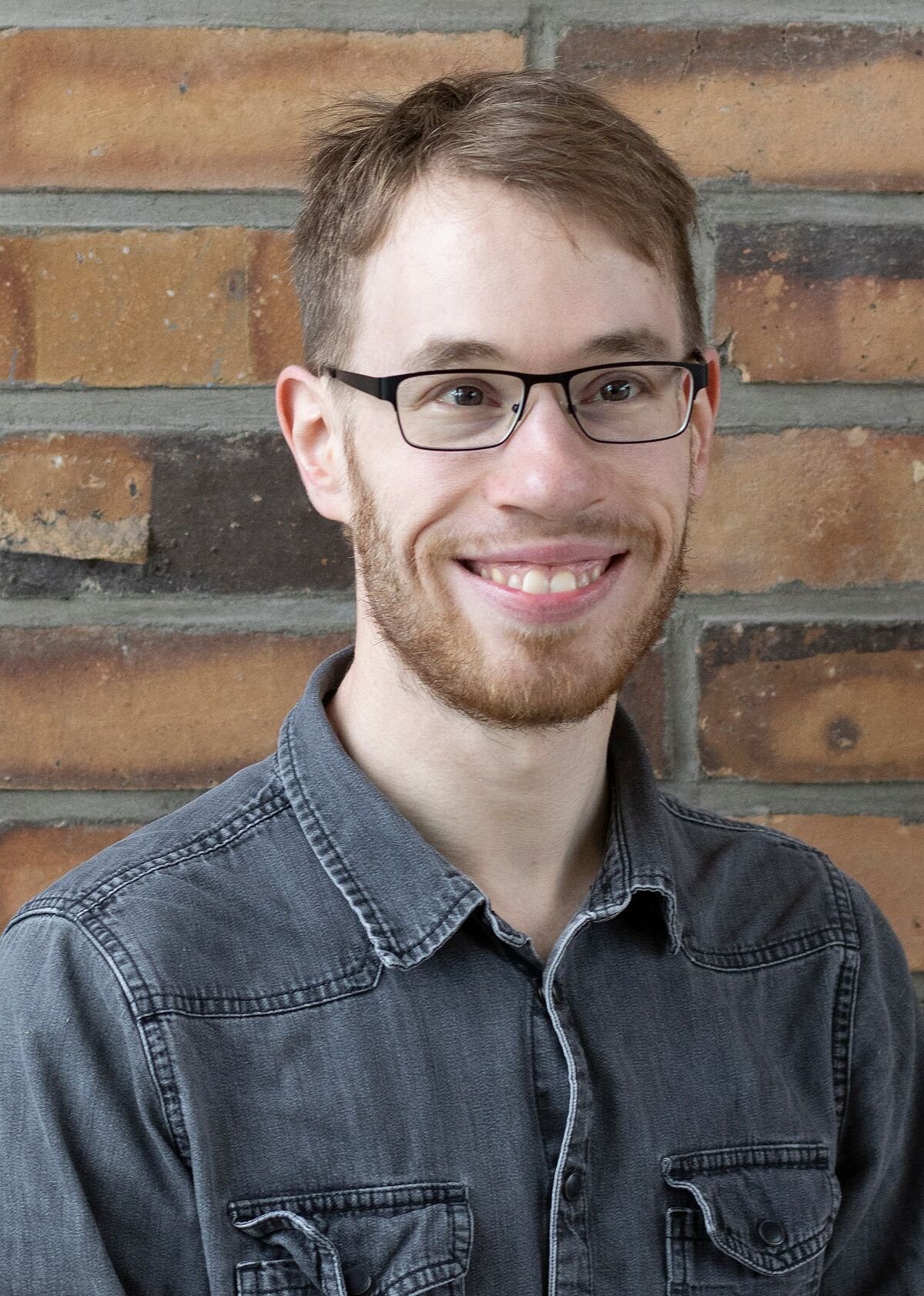 Portrait Julian Kirchgesser vor einer Steinwand